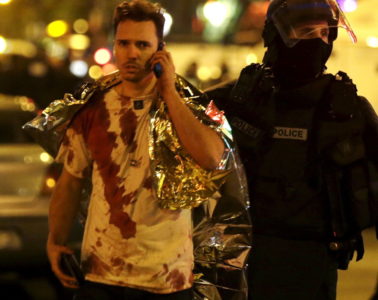 AFrenchpolicemanassistsablood coveredvictimneartheBataclanconcerthallfollowingattacksinParis,France