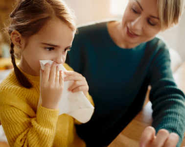 Little Girl Blowing Nose While Being With Her Mother At Home