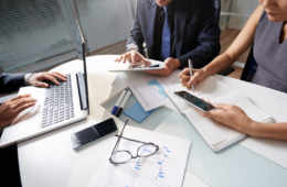 Business People Sitting At Office Desk Working On Project