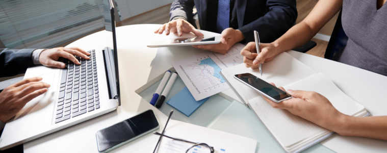 Business People Sitting At Office Desk Working On Project